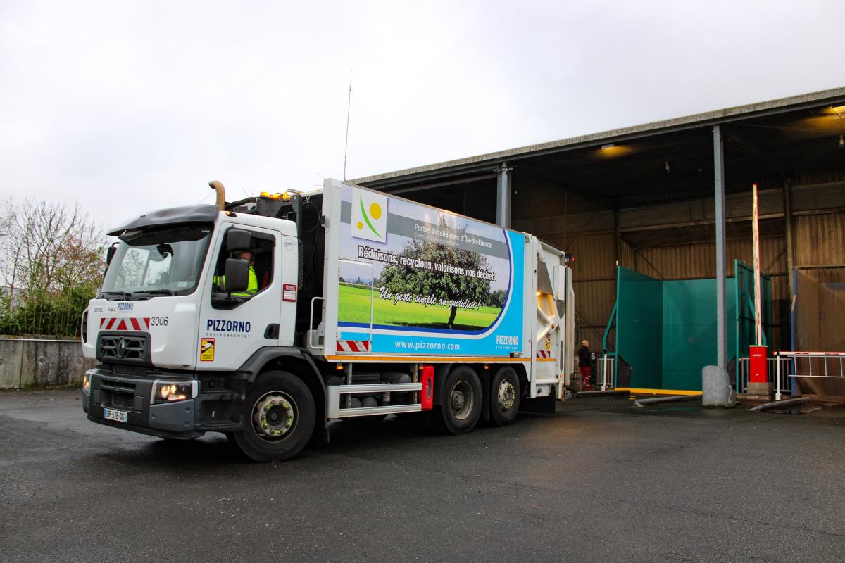 Un camion de collecte qui se positionne pour décharger les emballages dans le compacteur.